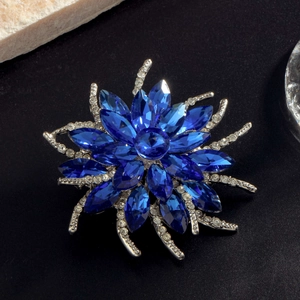 Broche fleur bleu roi élégante avec cristaux scintillants sur fond texturé noir