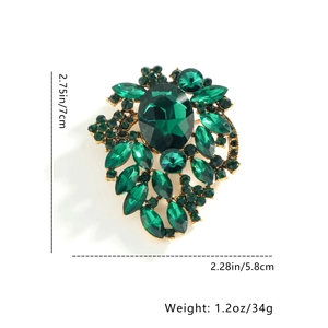 Detail showing leaf brooch dimensions of 7cm with green gems and rhinestone inlay