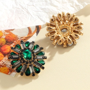 Radial sunflower brooch with green emerald gems and crystals on a golden base