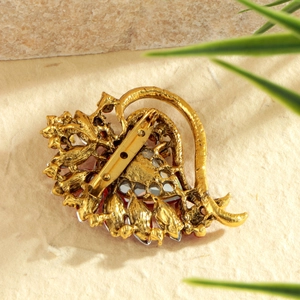 Back view of vintage gold heart brooch with red gemstones and secure pin clasp