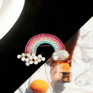 Fashionable rainbow and cloud brooch with sparkling rhinestones and a large iridescent gem