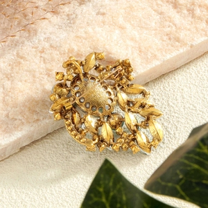 Back view of vintage gold leaf brooch showing safety pin clasp and textured alloy metal