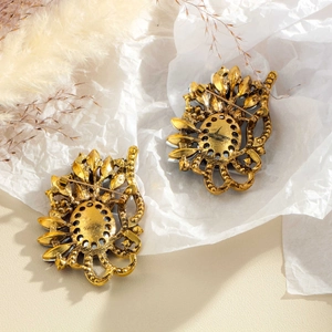 Vintage hollow gold brooch with colorful rhinestones shown from the back with safety pin