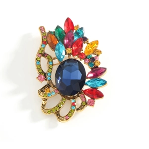 Vintage luxury gold brooch with multi-color crystals and central blue gemstone