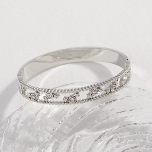Silver star-patterned steel bangle with clear crystals and beaded edge details
