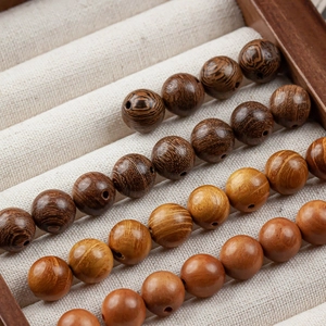 Macro detail of 10mm polished natural wood beads with distinct grain patterns
