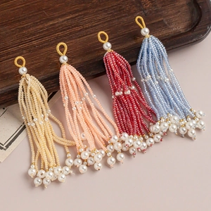 Détail de pendentifs à pompons perlés faits main en quatre couleurs vintage élégantes