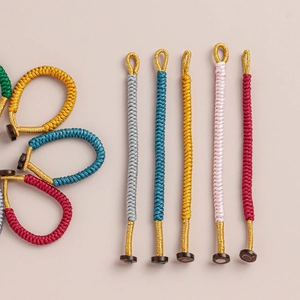 Macro detail of hand-woven Vajra knots in five colors with resin buckle and gold thread
