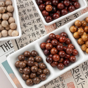 Assorted 10mm natural wooden beads for DIY jewelry making in a white grid display tray