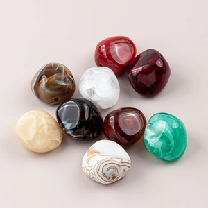 Macro shot of colorful irregular resin beads with marble texture and large holes for DIY jewelry