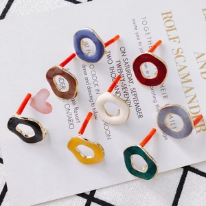 Gros plan de breloques de boucles d'oreilles émaillées géométriques de diverses couleurs