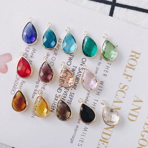 Macro shot of colorful waterdrop crystal pendants with gold plated alloy edges and rings