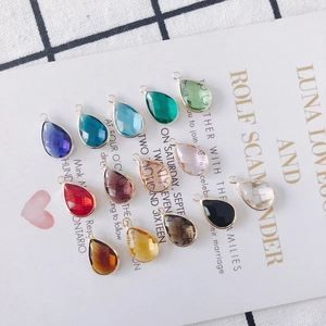 Detailed close-up of colorful teardrop crystal pendants with gold metal edges