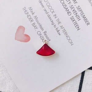 Close-up of a red fan-shaped gemstone pendant with gold-plated trim for DIY jewelry