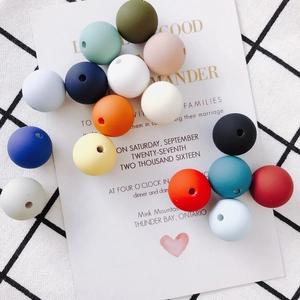 Flat lay of colorful 12mm matte silicone beads for DIY jewelry and baby pacifier clips