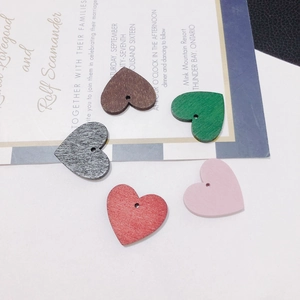 Macro detail of heart-shaped wooden beads in five colors for DIY jewelry making