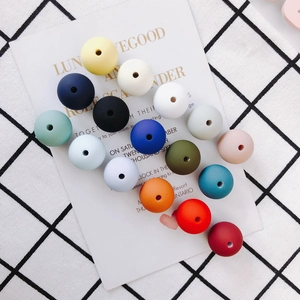 Macro detail of multicolored 15mm matte silicone round beads with central holes for DIY jewelry