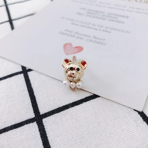 Macro shot of gold-plated teddy bear pendant with pearl accents for DIY jewelry making