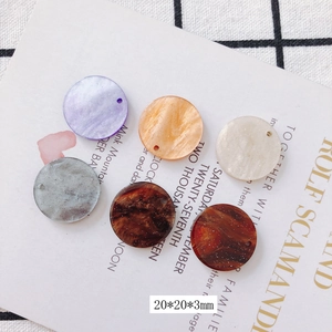 Detalle de dijes redondos de acrílico con purpurina 20x20x3mm para creación de joyas