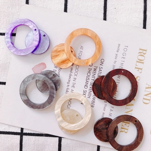 Vista detallada de anillos y discos acrílicos veteados para crear joyas personalizadas