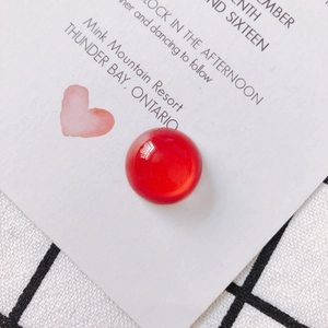Dettaglio di un cabochon rotondo in vetro rosso lucido per gioielli fai-da-te
