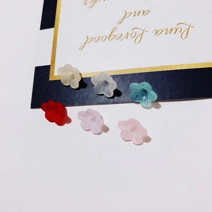 Macro detail of colorful matte resin flower petals with center holes for DIY jewelry