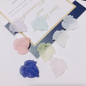 Close-up of matte leaf-shaped resin pendants with small holes for DIY jewelry making