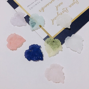 Close-up of colorful frosted resin maple leaf charms with pre-drilled holes for jewelry DIY