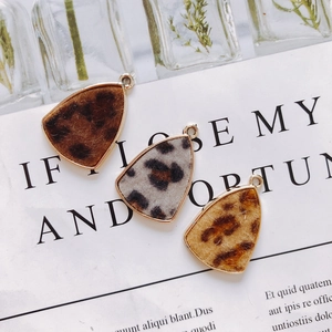 Detailed view of three leopard print triangle pendants with gold edges for DIY jewelry making