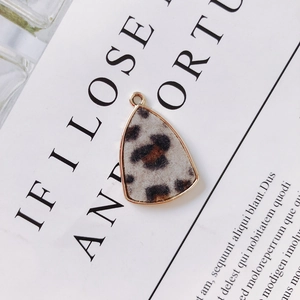 Macro detail of leopard print alloy pendant with gold plating for DIY jewelry making