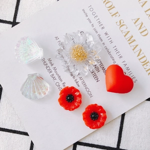 Assorted DIY jewelry charms featuring iridescent shells, matte hearts and acrylic flowers