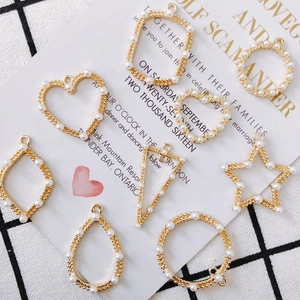 Macro detail of geometric gold pendants with white pearls for DIY jewelry making