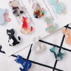 Vue macro de breloques chat en acrylique marbré avec trous pré-percés pour bijoux DIY