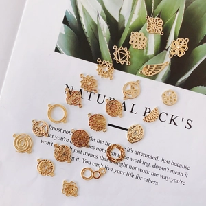 Flat lay of gold alloy jewelry charms with mandala and tree of life patterns