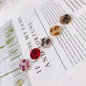 Detail of round leopard print alloy pendants in five colors for DIY jewelry crafting