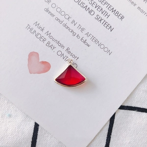 Vue macro d'un pendentif en cristal rouge en forme d'éventail avec bordure en métal doré