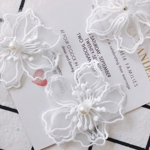 Fleur en dentelle brodée blanche avec perle centrale pour accessoires de boucles