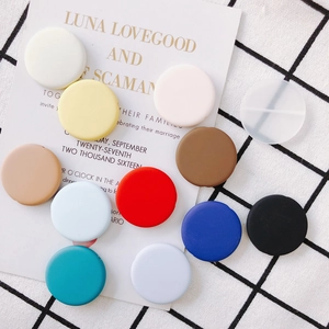 Flat lay of colorful matte DIY round flat beads and accessories on checkered background