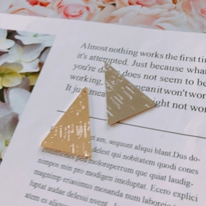 Gros plan de pendentifs triangulaires en métal doré et argenté pour bijoux DIY