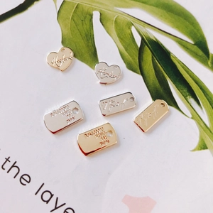 Vista macro de colgantes de corazón y rectangulares bañados en oro y plata para bricolaje