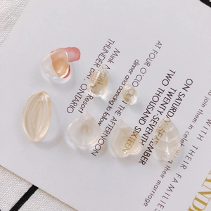 Detailed view of translucent leaf and petal glass beads for DIY jewelry making