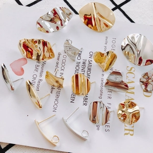 Detailed view of irregular geometric earrings with hammered metal texture in gold and silver