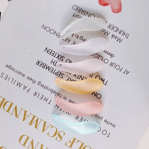Macro detail of leaf-shaped resin pendants in six matte pastel colors for DIY jewelry making