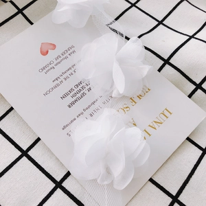 Detailed close-up of 3D white chiffon organza flower petals for DIY clothing accessories