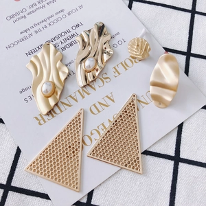 Detailansicht goldener geometrischer Ohrringe mit Perlen und hohlem Dreiecksdesign