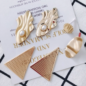 Makroaufnahme von goldenen Metallanhängern und Perlen für die DIY-Schmuckherstellung