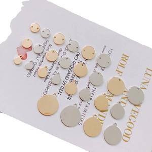 Flat lay of gold and silver plated round DIY jewelry charms and connectors on paper