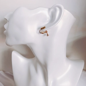 Detailed view of adjustable golden screw earring converter on a model ear