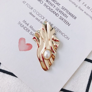 Detail eines goldenen gewellten Metallanhängers mit Perle für DIY-Schmuckdesign