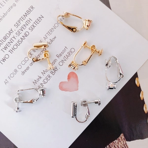 Detailed view of silver and gold screw-on earring converters for non-pierced ears